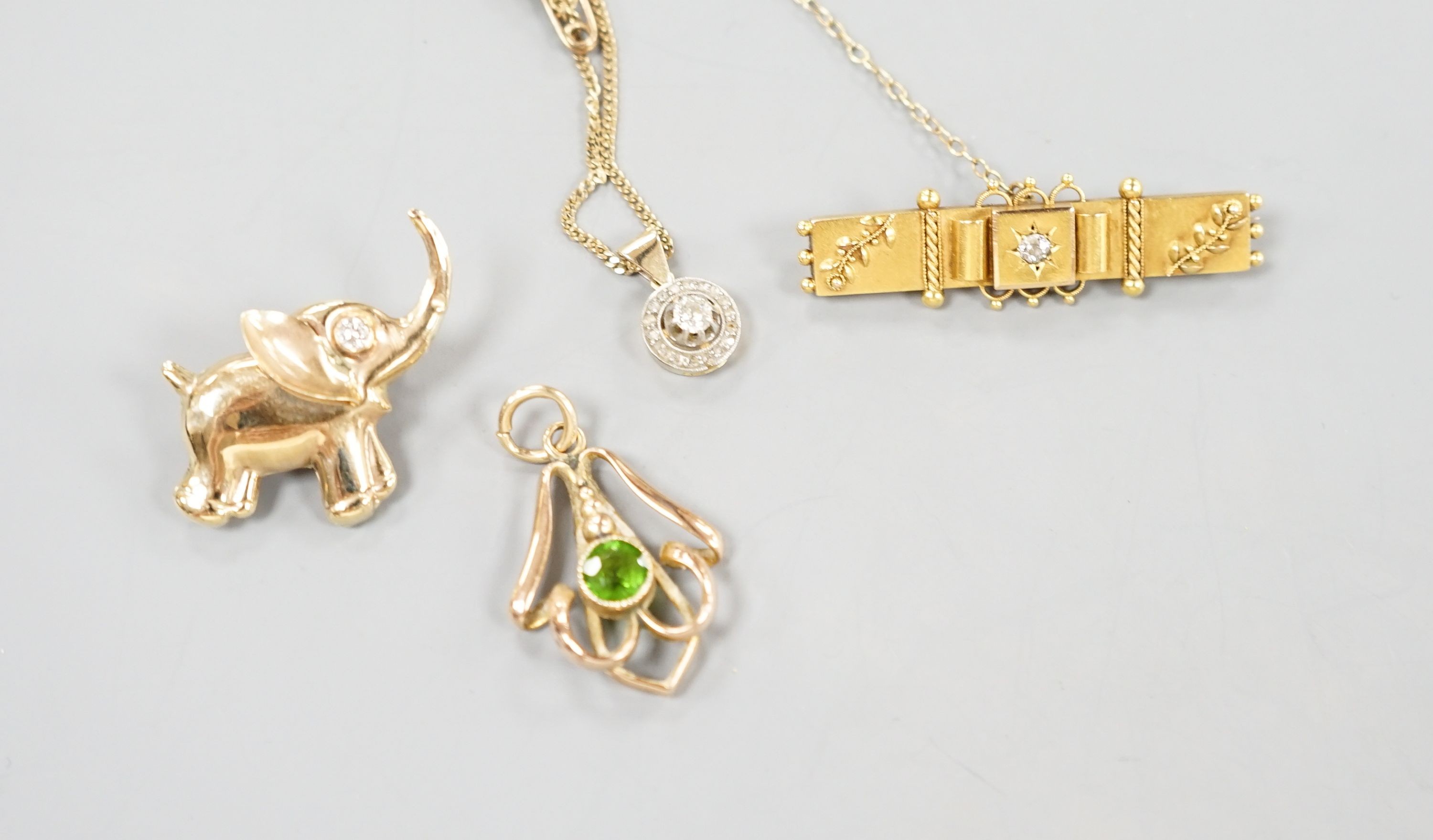 A yellow metal and diamond set clasp, now mounted as a pendant on later 9k chain, a yellow metal and diamond set elephant brooch, 31mm, a yellow metal and green stone doublet set pendant and a 15ct and diamond set bar br